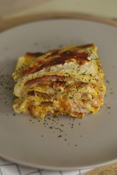 a white plate topped with lasagna covered in cheese