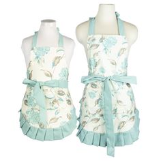 two aprons with blue flowers on them, one is white and the other is green