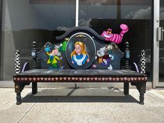 a bench with cartoon characters painted on it in front of a storefront display window