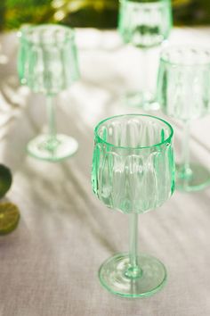 green wine glasses sitting on top of a table