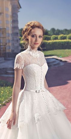 a woman in a white dress is standing outside