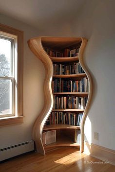 a curved book shelf in the corner of a room with a window and wooden floors