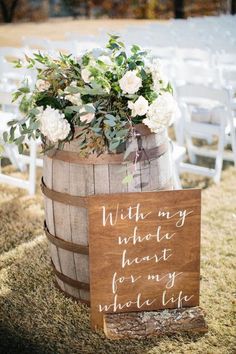 a wooden barrel filled with flowers and greenery next to a sign that says, with my hublot heart for my whole life