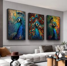 three paintings on the wall of a living room