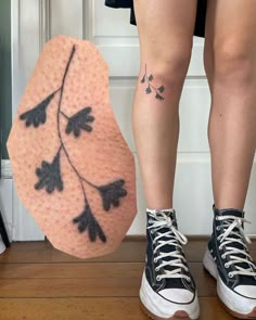 a woman's legs with tattoos on them next to an object that looks like a shoe