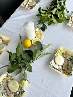 the table is set with lemons, plates and utensils