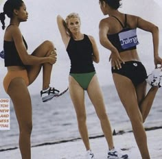 three women in bathing suits on the beach