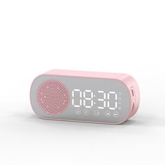 a pink alarm clock sitting on top of a white table