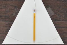 a piece of paper with a pencil sticking out of it on top of a wooden table