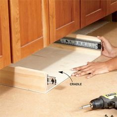 a woman laying on the floor with tools in front of her and an open drawer