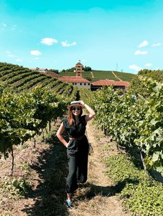 a woman standing in the middle of a vineyard