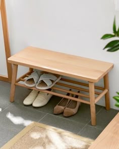 two pairs of shoes under a wooden bench