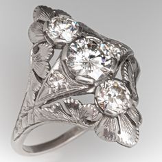 an antique style ring with three stones in the center and two leaves on each side