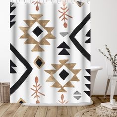 a white shower curtain with gold and black geometric designs on the outside, along with a wicker basket next to it