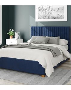 a bed with blue velvet headboard and pillows