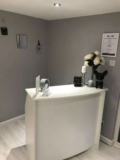 a white reception desk with flowers on top