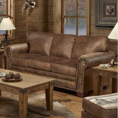 a living room filled with furniture and wooden flooring next to two lamps on either side of the couch