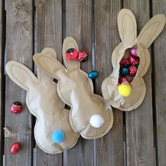 two bunny shaped bags sitting on top of a wooden table next to candy candies