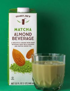 a carton of trader joe's matcha almond beverage next to a glass of milk