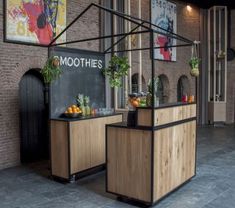 an outside bar with plants and fruit on the counter, in front of a brick wall