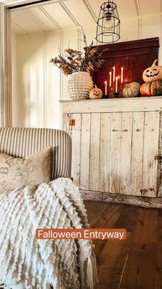 a living room decorated for halloween with pumpkins and candles on the fireplace mantel