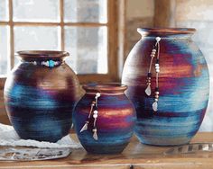 three vases sitting on top of a wooden table