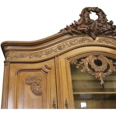 an ornate carved wooden cabinet with glass doors