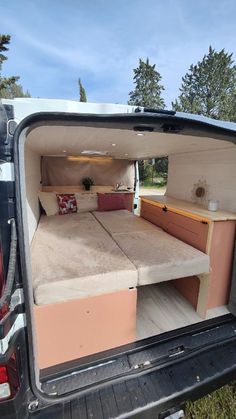 the back end of a van with a bed and desk in it's trunk