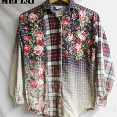 a shirt with flowers on it hanging on a hanger