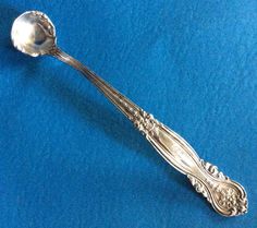 an antique silver spoon on a blue background