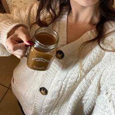 a woman is holding a jar of coffee