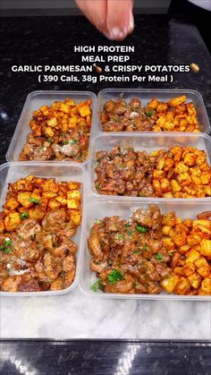 four plastic containers filled with food on top of a counter next to a person's hand