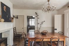 a dining room table with chairs and a chandelier hanging from it's ceiling