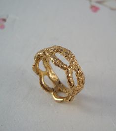 a gold ring sitting on top of a white table next to a flowery cloth