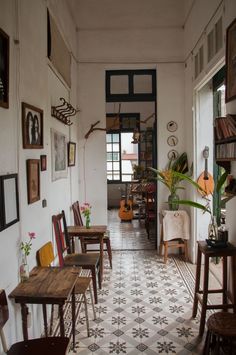 a room filled with lots of wooden tables and chairs next to a wall covered in pictures