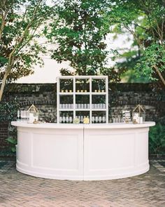 an outdoor bar with candles and bottles on it