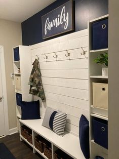 a white bench with blue and gray pillows on it in front of a family sign