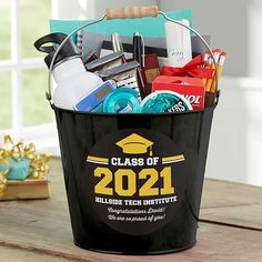 a bucket filled with school supplies on top of a wooden table