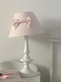 a white lamp with a pink bow on it