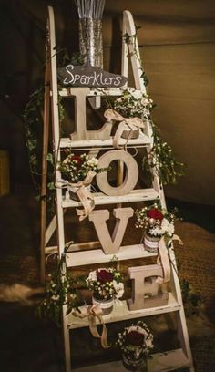 an old ladder decorated with flowers and greenery is used as a valentine's day decoration