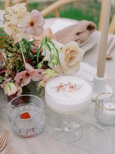 the table is set with flowers and candles