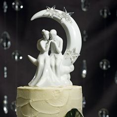 a wedding cake decorated with an image of the bride and groom kissing on the moon