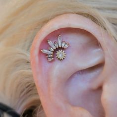 a close up of a person's ear with some piercings on it