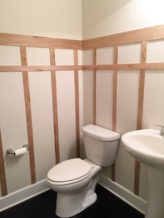 a white toilet sitting next to a sink in a bathroom under construction with wood framing