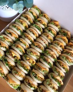 a box filled with lots of sandwiches on top of a table