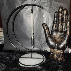 a hand that is next to a metal object on a black tablecloth covered surface