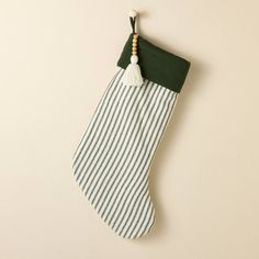 a green and white striped christmas stocking hanging on a wall