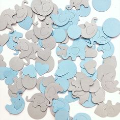 blue and gray elephant cutouts are scattered on a white surface, including one in the center