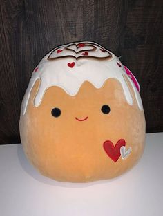 there is a stuffed toy that looks like a doughnut with icing and hearts on it