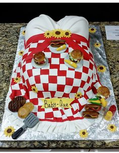 a cake made to look like a picnic blanket with hot dogs and hamburgers on it